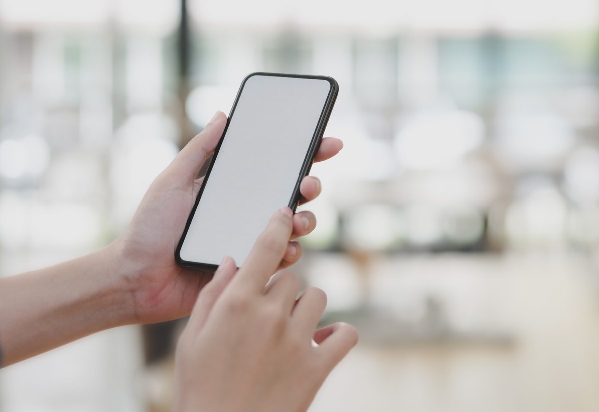 Mano sosteniendo un celular para reservar un turno